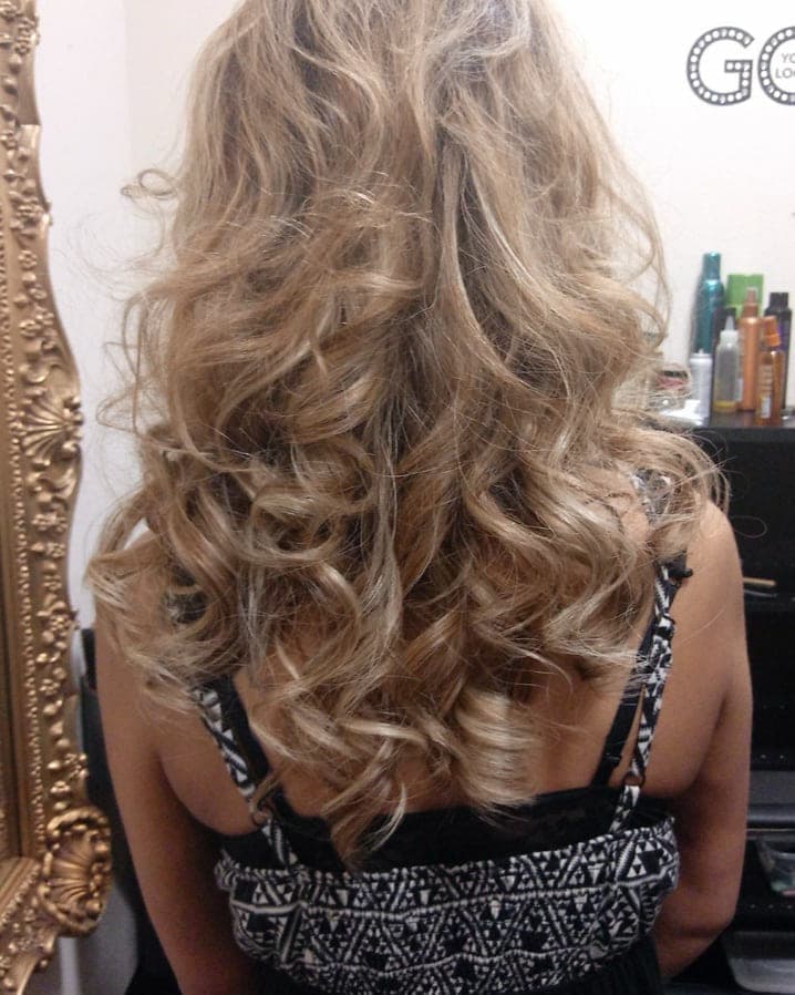Back view of long blonde hair finished in soft, defined curls
